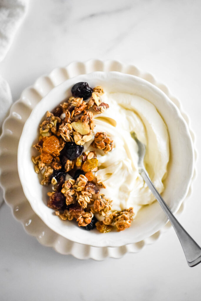 white bowl with yogurt and granola