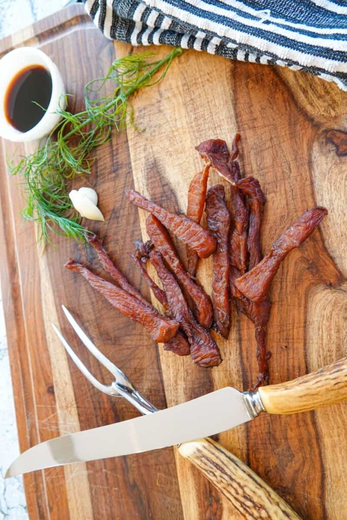 jerky on cutting board with meat carving knife