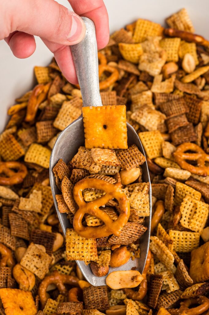 chex mix in tub with spoon in middle